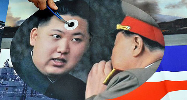 Um ativista sul-coreano marca uma foto do jovem líder norte-coreano Kim Jong-Un (esquerda), durante uma manifestação recente anti-Coreia do Norte realizada em Seul (Jung Yeon-Je/AFP/Getty Images)