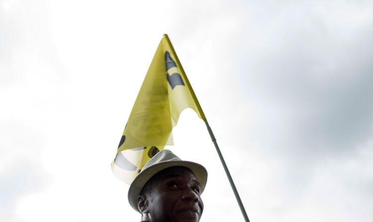 Um homem exibe um bandeira numa manifestação de imigrantes ilegais em Paris, França (Fred Dufour/AFP/Getty Images)