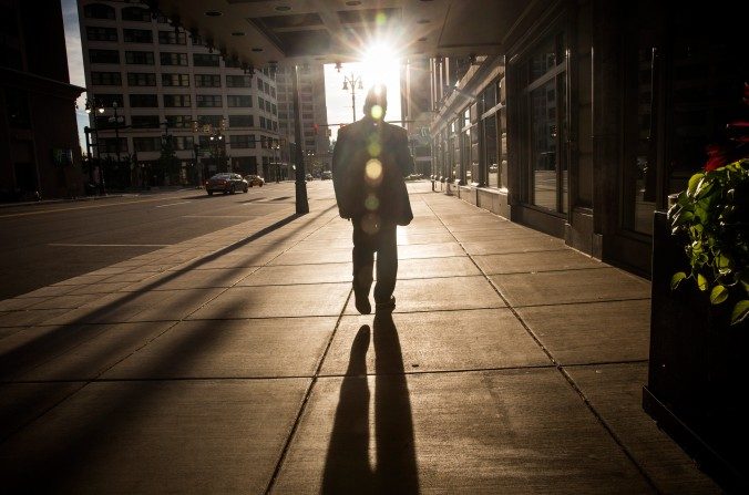 Um homem caminha em direção ao pôr do sol em Detroit, Michigan, EUA. Em julho, a cidade declarou falência (Andrew Burton/Getty Images)