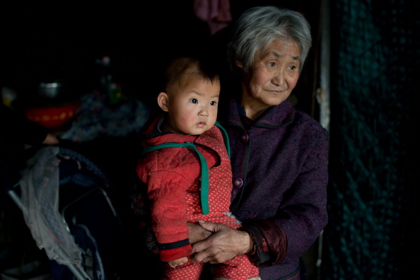 Uma chinesa com o neto em sua casa em Chengde, província de Hebei, uma cidade onde os habitantes não são restritos pela política do filho único de controle da natalidade como em outras partes da China. Esta política coercitiva foi discutida numa reunião recente do Partido Comunista Chinês (Ed Jones/AFP/Getty Images)