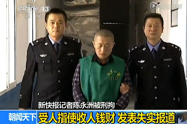 Chen Yongzhou, um repórter do New Express, é levado por policiais para se confessar na emissora estatal. Ele estava algemado, usando uniforme prisional e teve a cabeça raspada (V.qq.com)