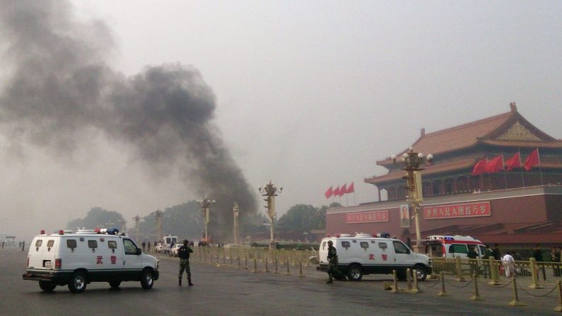 Viaturas da polícia bloqueiam os acessos a Praça da Paz Celestial enquanto um carro acidentado queima no fundo. O veículo pertencia a um uigur e os uigures temem que o incidente seja usado pelo regime chinês para justificar mais repressão (STR/AFP/Getty Images)