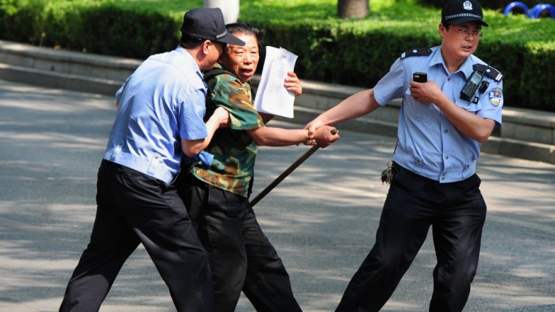 Uma peticionária é detida pela polícia fora do Hospital Chaoyang, onde o ativista e advogado chinês Chen Guangcheng estava detido, em Pequim, China (Mark Ralston/AFP/GettyImages)