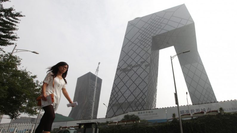 Uma chinesa passa em frente à matriz da China Central de Televisão (CCTV). O produtor Wang Qinglei foi forçado a se demitir após criticar o esquema de propaganda e censura usado contra os blogueiros na internet chinesa (Franko Lee/AFP/Getty Images)