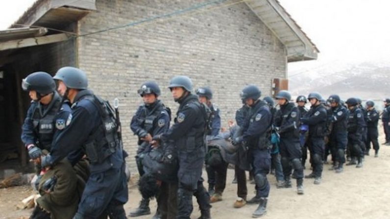 Escritores e artistas tibetanos têm sido alvos da última fase de repressão da China no Tibete. Na imagem, tibetanos são forçados a se curvar enquanto são arrastados pelas forças de segurança chinesas (Fórum Militar Chinês)