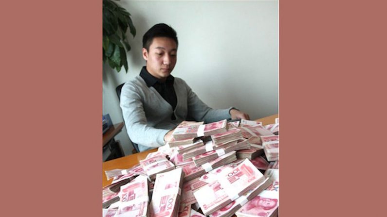 Um jovem chinês com uma pilha de dinheiro. Ele ofereceu mais de 165 mil dólares a uma mulher para que posasse como sua namorada por uma semana no feriado de Ano Novo Chinês (iWeju)
