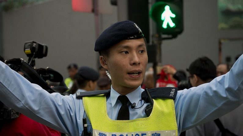 Um policial de Hong Kong orienta o público durante uma manifestação pró-democracia. Milhares marcharam em Hong Kong em 1º de janeiro pelo sufrágio universal na seleção da liderança regional, expressando medo de que a China limitará a tão esperada reforma política (Alex Ogle/AFP/Getty Images)