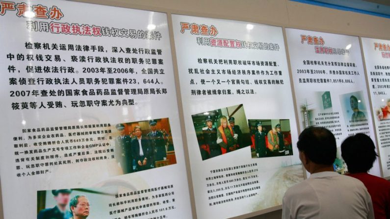 Visitantes observam painéis sobre membros supostamente corruptos do Partido Comunista Chinês, numa exibição em Pequim (Teh Eng Koon/AFP/Getty Images)