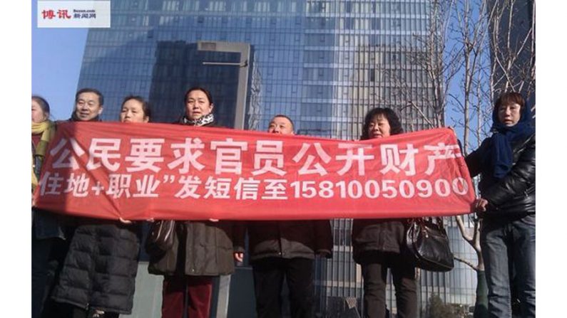 Durante o julgamento do defensor dos direitos Xu Zhihong em Pequim, em 22 de janeiro, o advogado Cheng Hai (extrema esquerda) e outros defensores dos direitos humanos seguraram uma faixa pedindo que funcionários do governo divulguem seus ativos (Boxun.com)