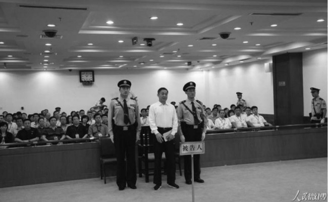 O político chinês desgraçado Bo Xilai entre dois oficiais num tribunal em Jinan, capital da província de Shandong. A prisão de Bo Xilai em março de 2012 marcou o início de uma campanha para quebrar o poder do maciço do aparato de segurança interna do regime chinês (Weibo.com)