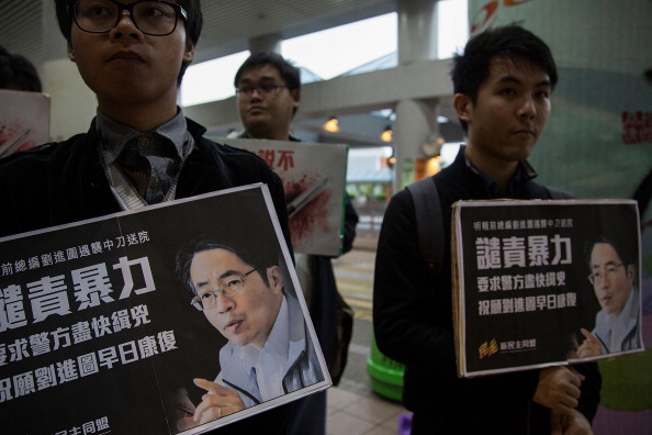 Ativistas pró-democracia exibem um cartaz com a imagem de Kevin Lau Chun-to, o ex-editor-chefe do jornal Ming Pao, enquanto participam numa vigília de velas. Lau foi esfaqueado por dois agressores e ficou gravemente ferido em 26 de fevereiro (Lam Yik Fei/Getty Images)