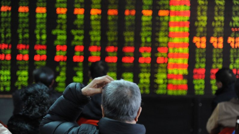 Um investidor observa um painel eletrônico numa bolsa de valores em Shenyang, China. Analistas financeiros estão preocupados com a crescente bolha de crédito da China (ChinaFotoPress/Getty Images)