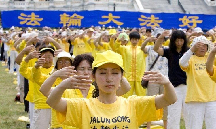 Centenas de praticantes do Falun Gong fazem exercícios no grande gramado em frente ao Capitólio dos EUA em 12 de julho antes de uma atividade que destacou a perseguição ao Falun Gong que ocorre na China (Ma Youzhi/Epoch Times)