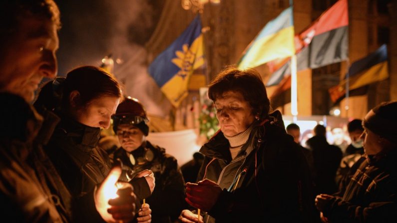 Orações são realizadas pelas vítimas que morreram nas manifestantes antigoverno, nos confronto com a polícia na Praça da Independência, apesar de uma trégua acordada entre o presidente ucraniano e os líderes da oposição em 20 de fevereiro de 2014, em Kiev, Ucrânia (Jeff J. Mitchell/Getty Images)