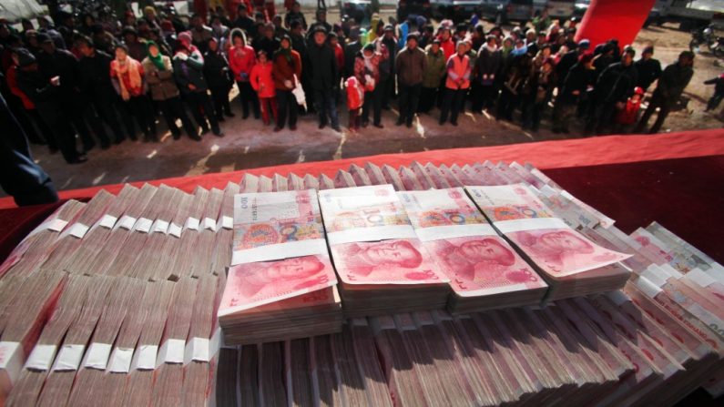 Aldeões se reúnem para receber sua parte dos 1 milhão de yuanes (US$ 165 mil) pagos em bônus anual pela companhia de chá de sua vila no subúrbio de Jinan, província de Shandong, Leste da China, em 20 de janeiro de 2014 (STR/AFP/Getty Images)