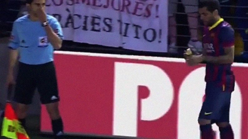 Torcida joga banana em Daniel Alves, que a pega e come durante jogo do Barcelona (Reprodução / ESPN)