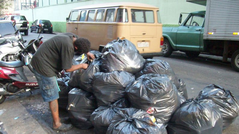 Em busca de coisas que resultem em dinheiro, morador de rua recorre às próprias unhas para abrir sacos de lixo na baixada do Glicério, região central de Sao Paulo (Milton Jung/Flickr)