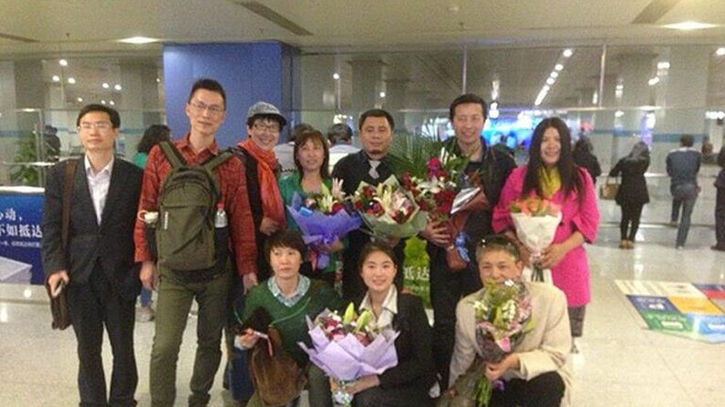 Cidadãos chineses acolhem os advogados Tang Jitian (atrás, segundo da direita) e Wang Cheng (atrás, terceiro da direita) no aeroporto de Pequim, em 6 de abril. Três advogados foram libertados no domingo depois de duas semanas de detenção num campo de trabalho forçado na província de Heilongjiang (Twitter)