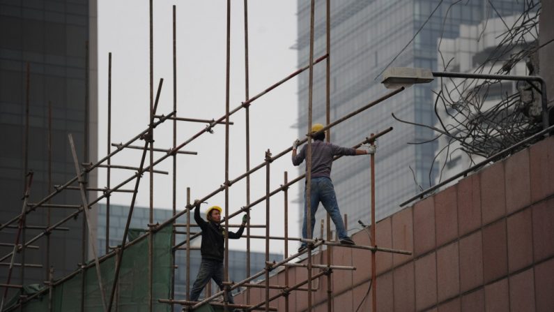 Dois trabalhadores chineses se preparam para retirar andaimes numa construção em Pequim em 15 de abril de 2014. Dados econômicos chineses vieram mais ou menos como esperados no primeiro trimestre de 2014 (Wang Zhao/AFP/Getty Images)