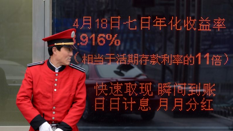 Um guarda diante de um painel eletrônico na frente de um banco de Pequim (Wang Zhao/AFP/Getty Images)