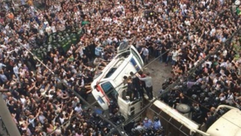 Uma multidão enfurecida vira uma ambulância na cidade de Wenzhou, província de Zhejiang, em 19 de abril. Mais de mil pessoas cercaram cinco oficiais chengguan, uma espécie de guarda municipal, depois que estes agrediram um espectador (Weibo)