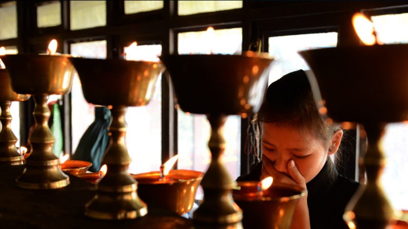 Filha de vítima da avalanche do Monte Everest acende velas para seu pai, o sherpa Ang Kazi, no Mosteiro em Kathmandu no dia 20 de abril de 2014 (Prakash Mathema / AFP / Getty Images)