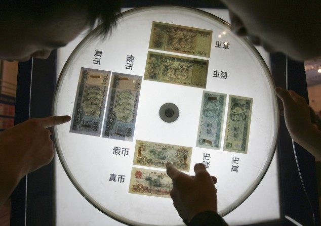 Um mostruário exibe notas de yuan e explica como identificar notas falsas, numa exposição no Museu da Ciência de Pequim, China. Uma enorme dívida está sendo acumulada na China na busca frenética por crescimento econômico (China Photos/Getty Images)