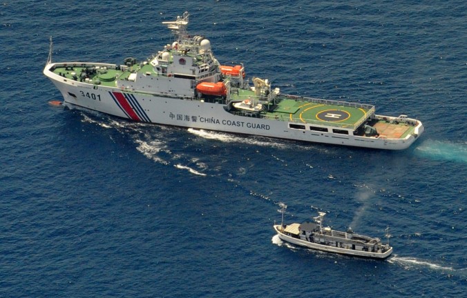 Um navio da Guarda Costeira da China (em cima) e um barco de abastecimento filipino se envolvem num impasse enquanto o barco filipino tenta alcançar o 2º Recife Thomas, uma formação remota no Mar do Sul da China reivindicada por ambos os países, em 29 de março (Jay Directo/AFP/Getty Images)