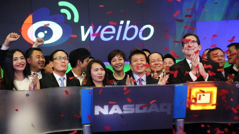 Charles Chao (centro), o presidente do Weibo, ao lado de Robert Greifel, o CEO da NASDAQ, momentos depois do Weibo começar a negociar na bolsa, em Nova York, 17 de abril (Spencer Platt/Getty Images)