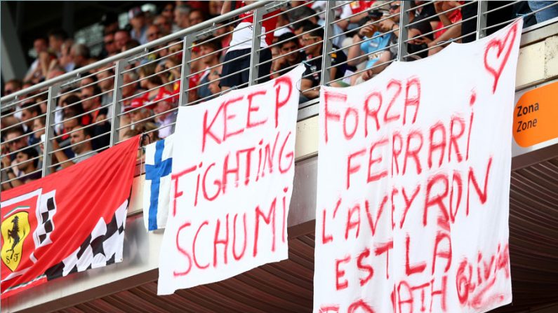 O banner à esquerda exibe a mensagem "continue lutando Schumi" durante o Grand Prix de Fórmula 1 no GP de Montmelo, na Espanha (Clive Mason / Getty Images)