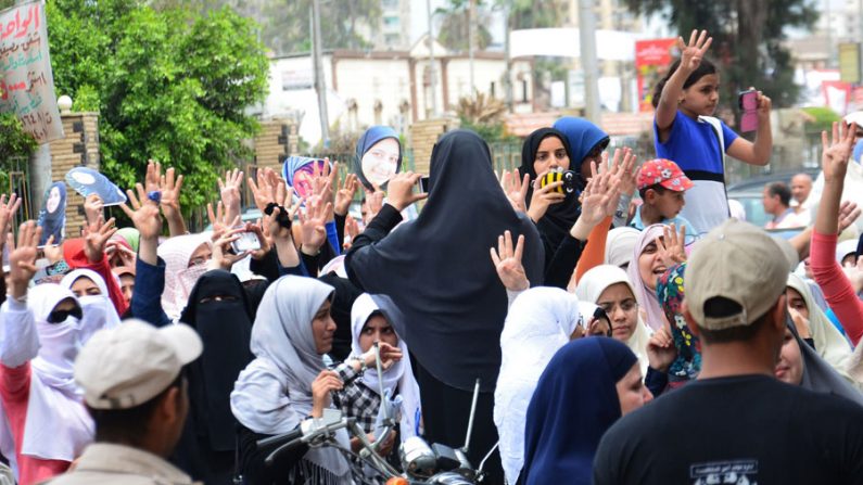 Familiares das vítimas da repressão a Irmandade Muçulmana no ano passado, se reúnem do lado de fora do tribunal penal que condenou 155 membros em Mansura, Egito (Sayed Baz / AFP / Getty Images)