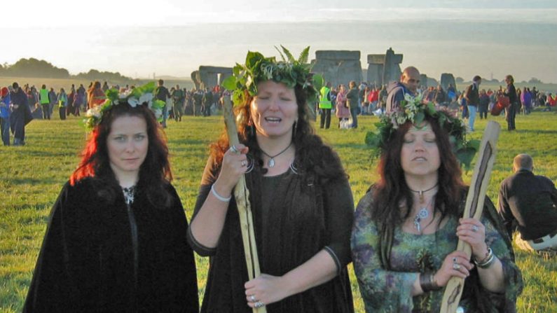 Três mulheres druidas na manhã do solstício de verão em Stonehenge, após o nascer do sol. Eles vestem roupas marrons e verdes em solidariedade com a Mãe Terra (Andrew Dunn/Wikimedia Commons)