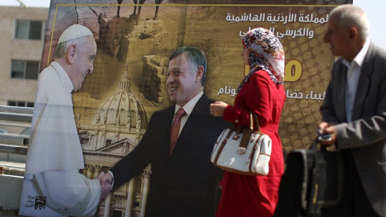 Cartaz mostra o rei da Jordânia Abdullah II (D) apertando as mãos de Papa Francisco durante sua visita ao Vaticano (Patrick Baz / AFP / Getty Images)