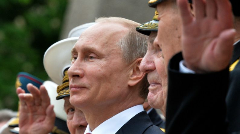 O presidente da Rússia Vladimir Putin e veteranos da Segunda Guerra Mundial assistem a desfile da guarda de honra durante sua visita ao porto da Crimeia em Sevastopol, em 9 de maio de 2014. A visita de Putin a Crimeia, que foi anexada por Moscou em março, é uma "flagrante violação" da soberania da Ucrânia, declararam autoridades de Kiev (Yuri Kadobnov/AFP/Getty Images)