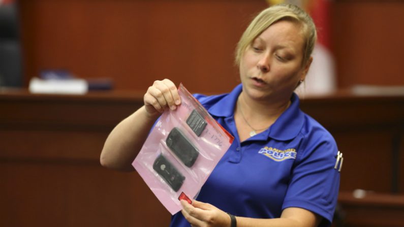 Diana Smith, perita do Departamento de Polícia de Sanford, mostra ao júri um telefone celular que foi coletado como evidência na cena de um crime, em 25 junho de 2013 em Sanford, Flórida (Gary W. Green-Pool/Getty Images)