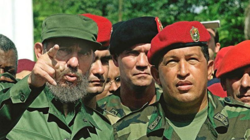 O presidente cubano, Fidel Castro (esq.) fala com o presidente venezuelano, Hugo Chávez (dir.) durante a sua visita ao monumento do soldado desconhecido em Campo Carabobo, Valencia, Venezuela, em 29 de outubro de 2000 (Adalberto Roque/AFP/Getty Images)