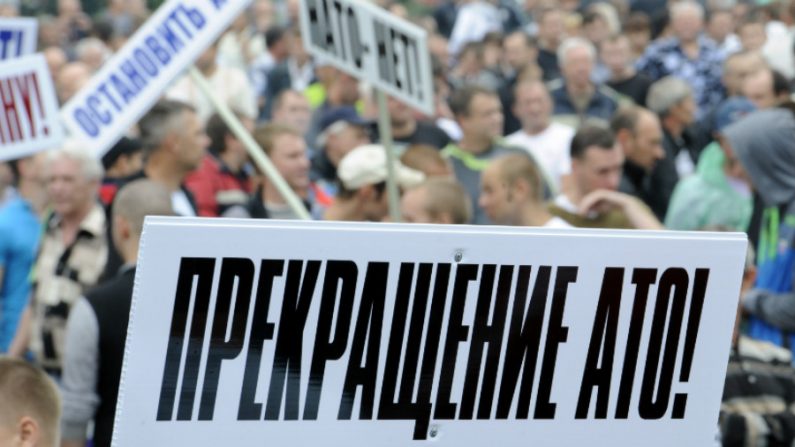 Pessoas seguram cartaz com os dizeres 'Não queremos ATO! (operação anti-terrorista), durante um comício em apoio à auto-proclamada 'República Popular de Donetsk', em Donetsk, na Ucrânia oriental, em 18 de junho de 2014 (Alexander Khudoteply/AFP/GettyImages)