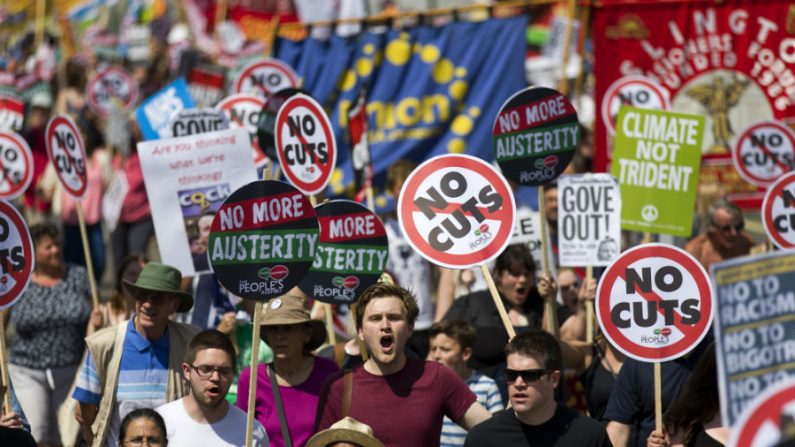 Manifestantes seguram cartazes em protesto contra as medidas de austeridade do governo na Praça do Parlamento em Londres, em 21 de junho de 2014 (Justin Tallis/AFP/Getty Images)