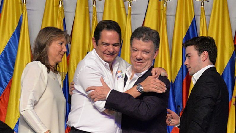 O presidente da Colômbia e candidato presidencial Juan Manuel Santos (centro dir.) comemora com seu vice-presidente Vargas Lleras (centro esq.) depois de conhecer os resultados do segundo turno da eleição presidencial em 15 de junho de 2014 em Bogotá. Santos foi reeleito com 50,90% dos votos, contra 45,04% para o conservador Oscar Ivan Zuluaga, com 99,37% dos votos computados (Diana Sanchez/AFP/Getty Images)