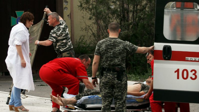 Equipe de emergência resgata feridos na cidade ucraniana oriental de Lugansk em 3 de junho de 2014, depois do pesado combate entre militantes pró-russos e o exército ucraniano (Sergey Gapon/AFP/Getty Images)