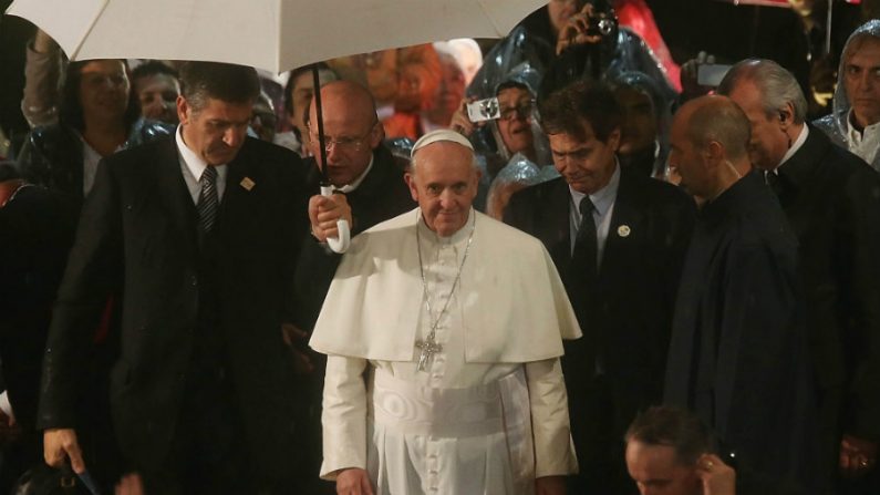 Papa Francisco (centro) sai na chuva depois de falar no Hospital de São Francisco de Assis em 24 de julho de 2013, no Rio de Janeiro, Brasil (Mario Tama/Getty Images)