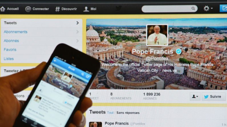 Um homem segura um smartphone mostrando o primeiro tweet do Papa Francisco em 17 de março de 2013, em Roma (Gabriel Bouys/AFP/Getty Images)