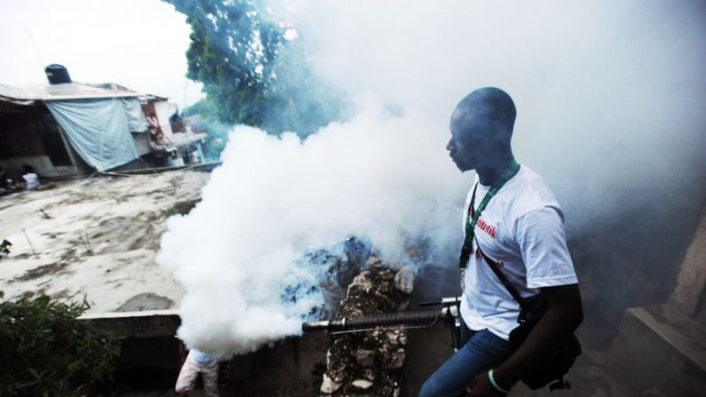 Haitiano joga produto químico para matar o mosquito transmissor da febre chikungunya (Hector Retamal / AFP / Getty Images)