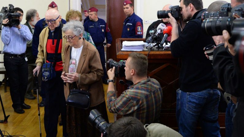 O ex-líder comunista húngaro Béla Biszku (2º esq.) chega à sala do tribunal antes de seu julgamento, em 13 de maio de 2014, em Budapeste, Hungria. Promotores húngaros apresentaram acusações de crimes de guerra em outubro passado contra Biszku, e iniciaram as declarações com a acusação de 'participação ativa' na decisão das forças de segurança para abrir fogo contra multidões em dois incidentes em dezembro de 1956, durante os quais cerca de 50 pessoas foram mortas (Attila Kisbenedek/AFP/Getty Images)