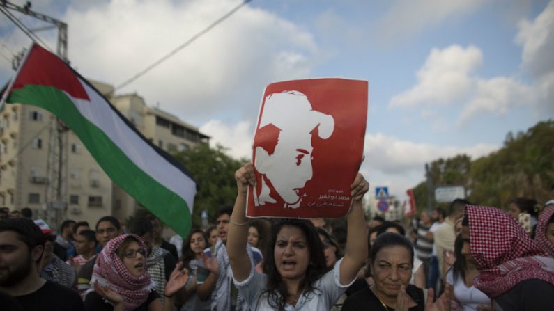 Manifestante segura um retrato de Mohammed Abu Khder, um palestino de 16 anos de idade, de Jerusalém Oriental, que foi sequestrado e morto em um suposto ato de vingança, durante um protesto no norte da cidade árabe israelense de Acre em 7 de julho de 2014. Três extremistas judeus foram presos pela morte de Khder e confessaram o crime (Ahmad Gharabli/AFP/Getty Images)