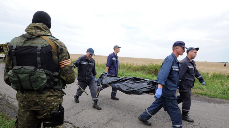 Separatista pró-Rússia observa ucranianos durante resgate dos corpos do acidente da Malaysia Airlines em Donetsk, Ucrânia (Dominique Faget / AFP / Getty Images)