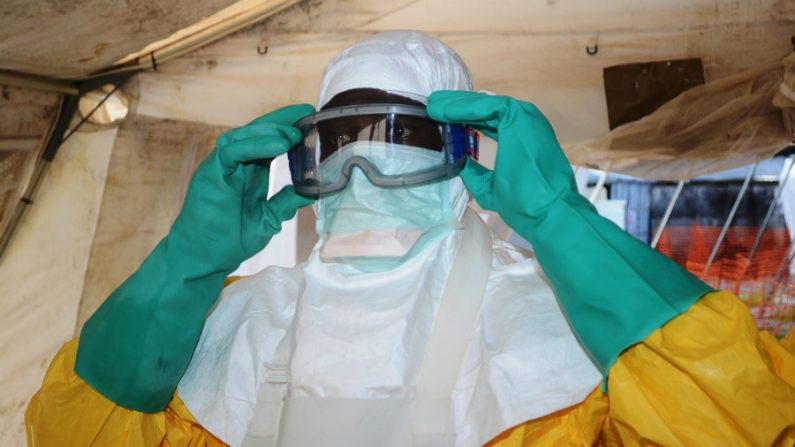  Foto tirada em 28 de junho de 2014 mostra um membro do grupo Médicos Sem Fronteiras (MSF) colocando equipamentos de proteção na ala de isolamento do Hospital Donka, em Conacri, onde as pessoas infectadas com o vírus Ebola estão sendo tratadas. A Organização Mundial da Saúde alertou que o Ebola poderia se espalhar para nações vizinhas aos três países primeiramente infectados - Serra Leoa, Libéria e Guiné, mas insistiu que a proibição de viagens não era necessária (Cellou Binani/AFP/Getty Images)