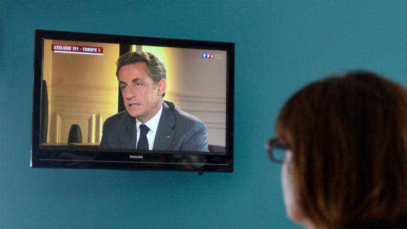 Mulher assiste a uma entrevista na televisão com o ex-presidente da França, Nicolas Sarkozy, depois que ele foi acusado de corrupção e tráfico de influência, em Lille, norte da França, em 2 de julho de 2014 (Denis Charlet/AFP/Getty Images)