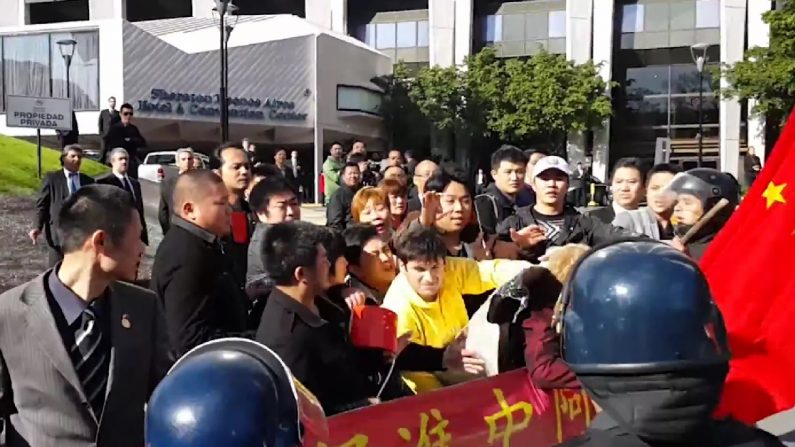 Chineses cercaram os praticantes argentinos do Falun Dafa e tentaram arrancar suas faixas com empurrões e agressão física (Epoch Times)