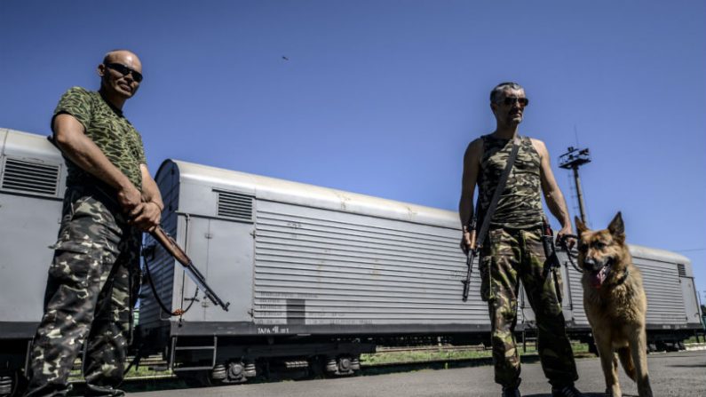 Separatistas pró-russos armados montam guarda na frente de vagões contendo os restos mortais de vítimas do avião da Malásia Airlines voo MH17, em uma estação de trem na cidade ucraniana oriental de Torez em 21 de julho de 2014 (Bulent Kilic/AFP/Getty Images)